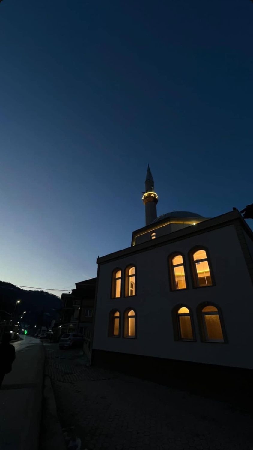 Džamija Rečane noću, osvijetljeni prozori i minaret
